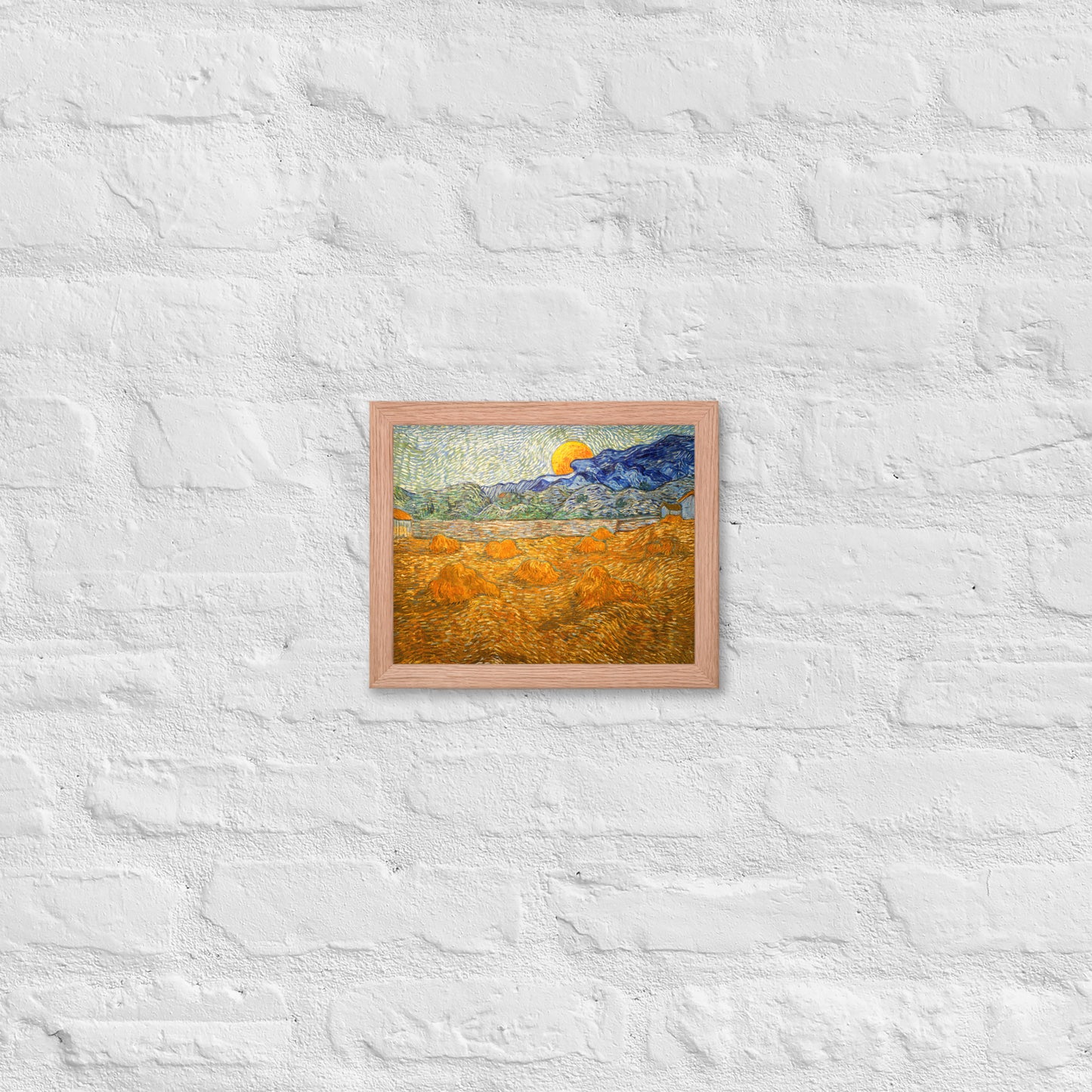 Van Gogh's 'Landscape with Wheat Sheaves and Rising Moon' on a 8"x10" red oak framed poster print on a white brick wall.