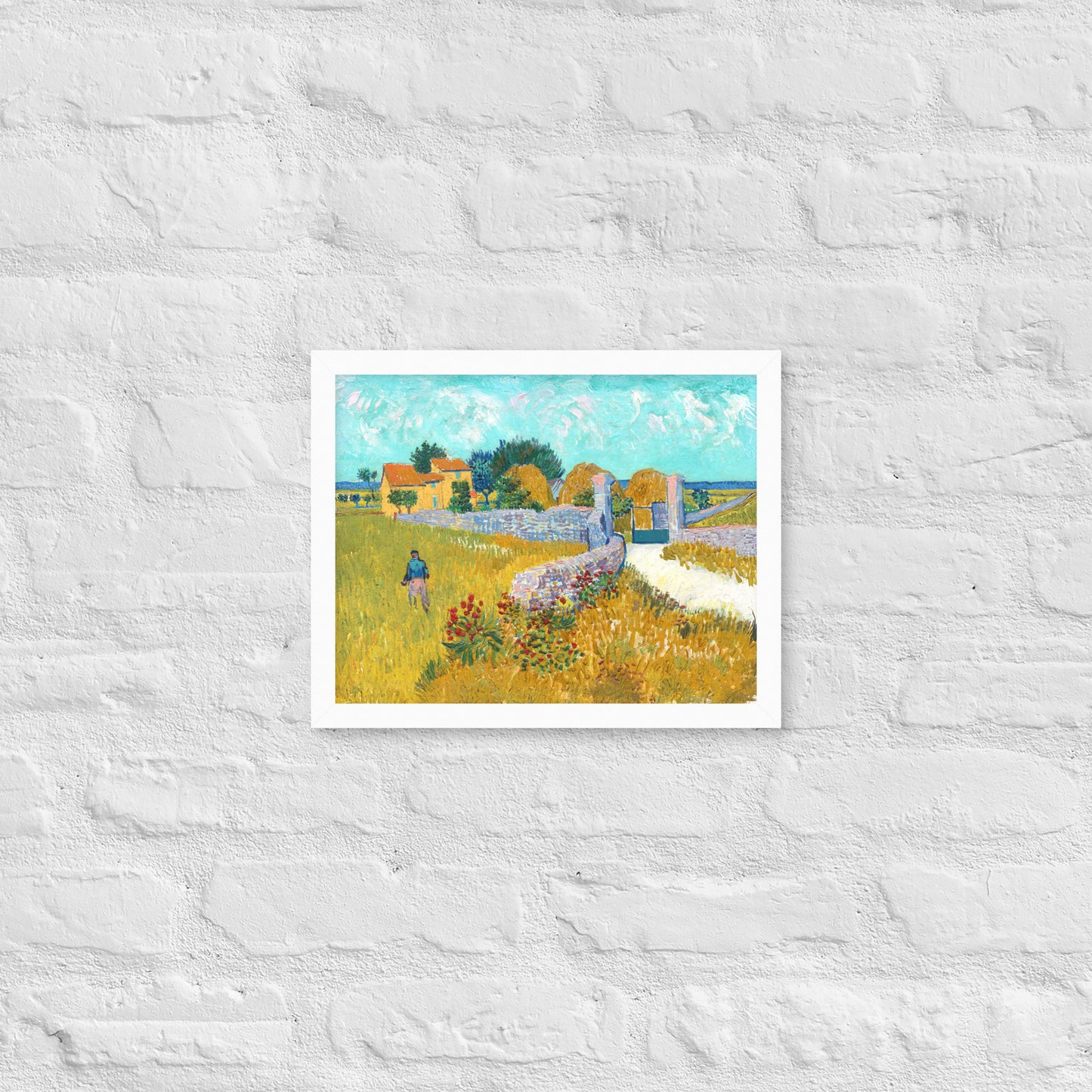Van Gogh's 'Farmhouse in Provence' on a 11"x14" white framed poster print on a white brick wall.