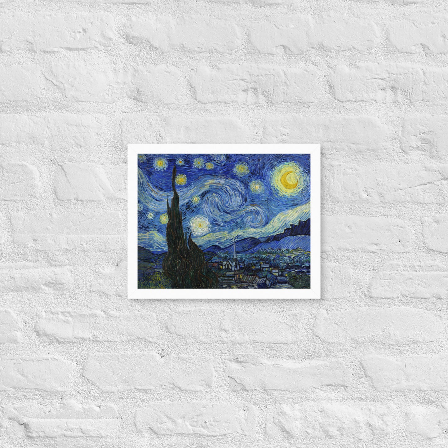 Van Gogh's 'Starry Night' on a 11"x14" white framed poster print on a white brick wall.