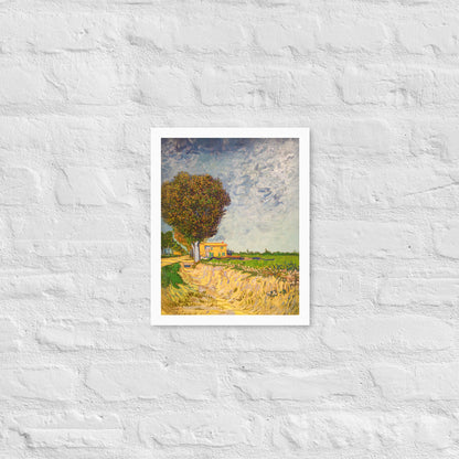 Van Gogh's 'A Lane near Arles' on a 11"x14" white framed poster print on a white brick wall.