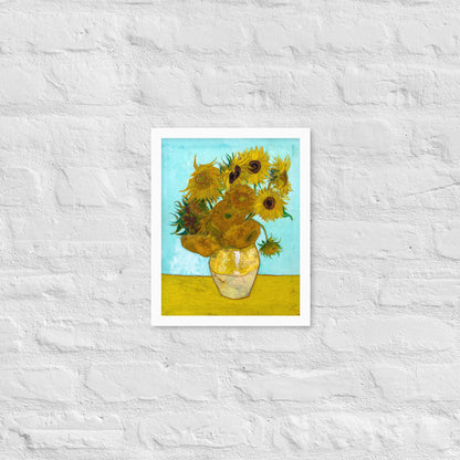 Van Gogh's 'Vase with Twelve Sunflowers' on a 11"x14" white framed poster print on a white brick wall.