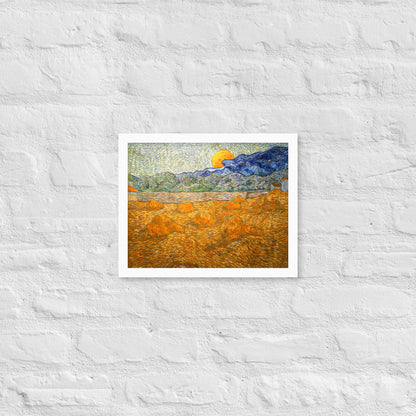 Van Gogh's 'Landscape with Wheat Sheaves and Rising Moon' on a 11"x14" white framed poster print on a white brick wall.