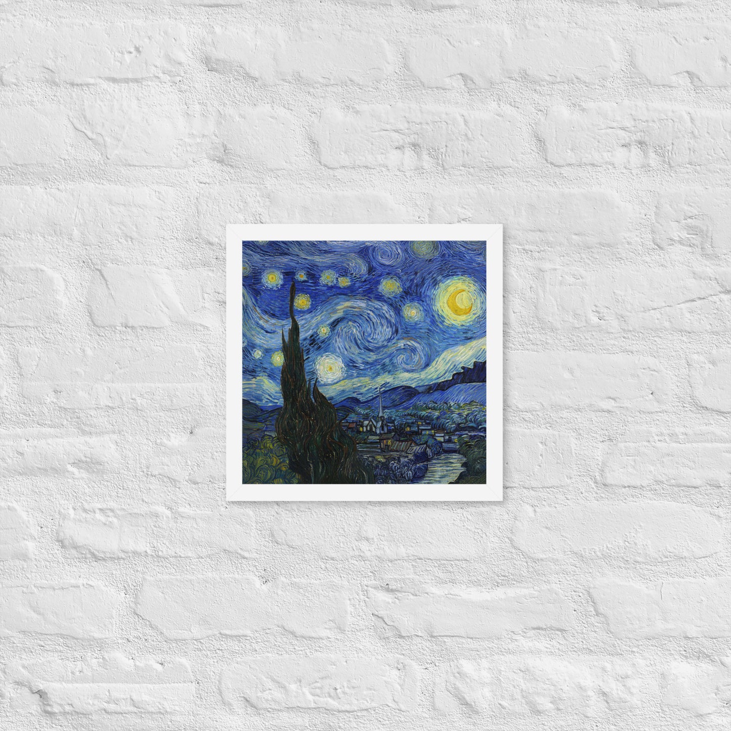 Van Gogh's 'Starry Night' on a 12"x12" white framed poster print on a white brick wall.