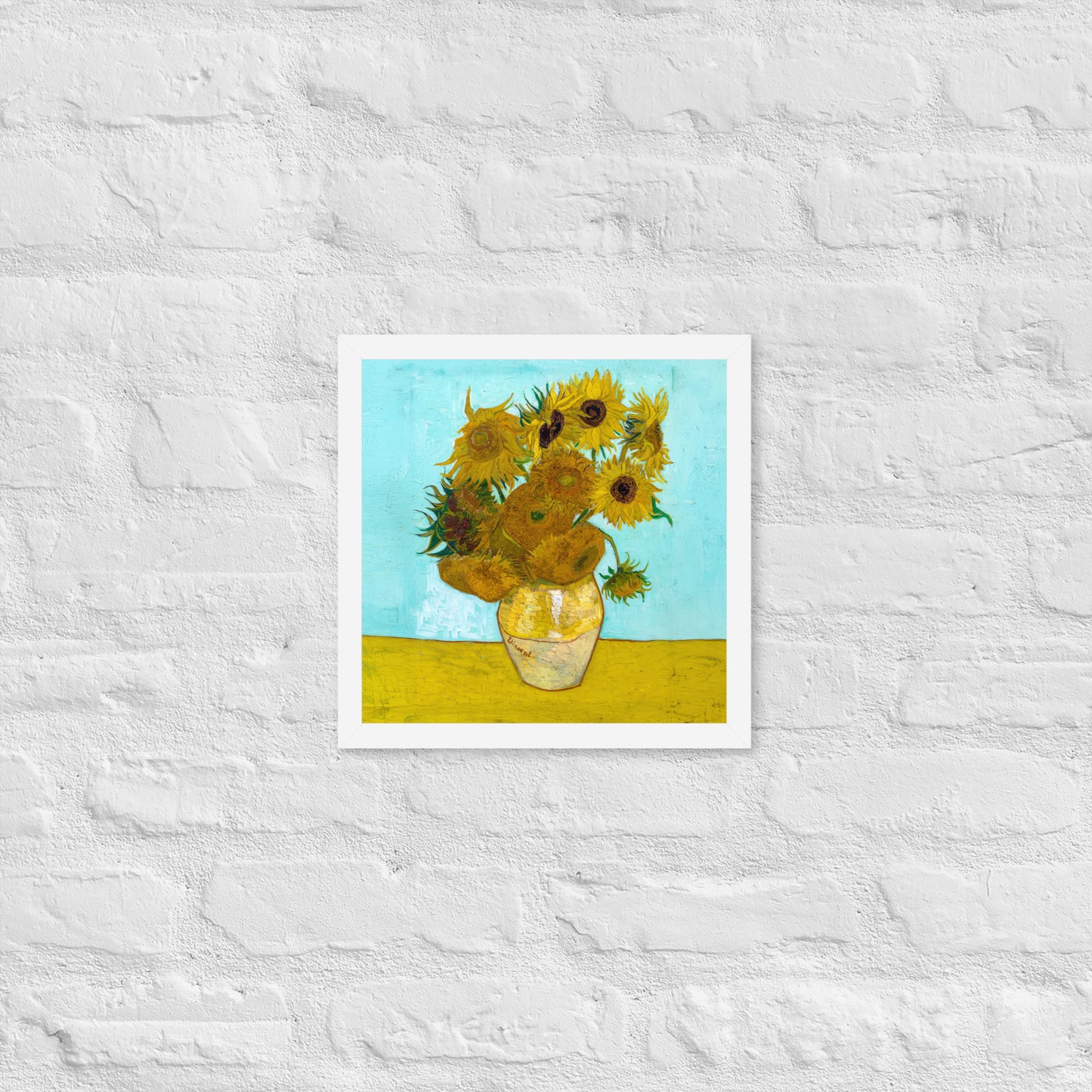 Van Gogh's 'Vase with Twelve Sunflowers' on a 12"x12" white framed poster print on a white brick wall.