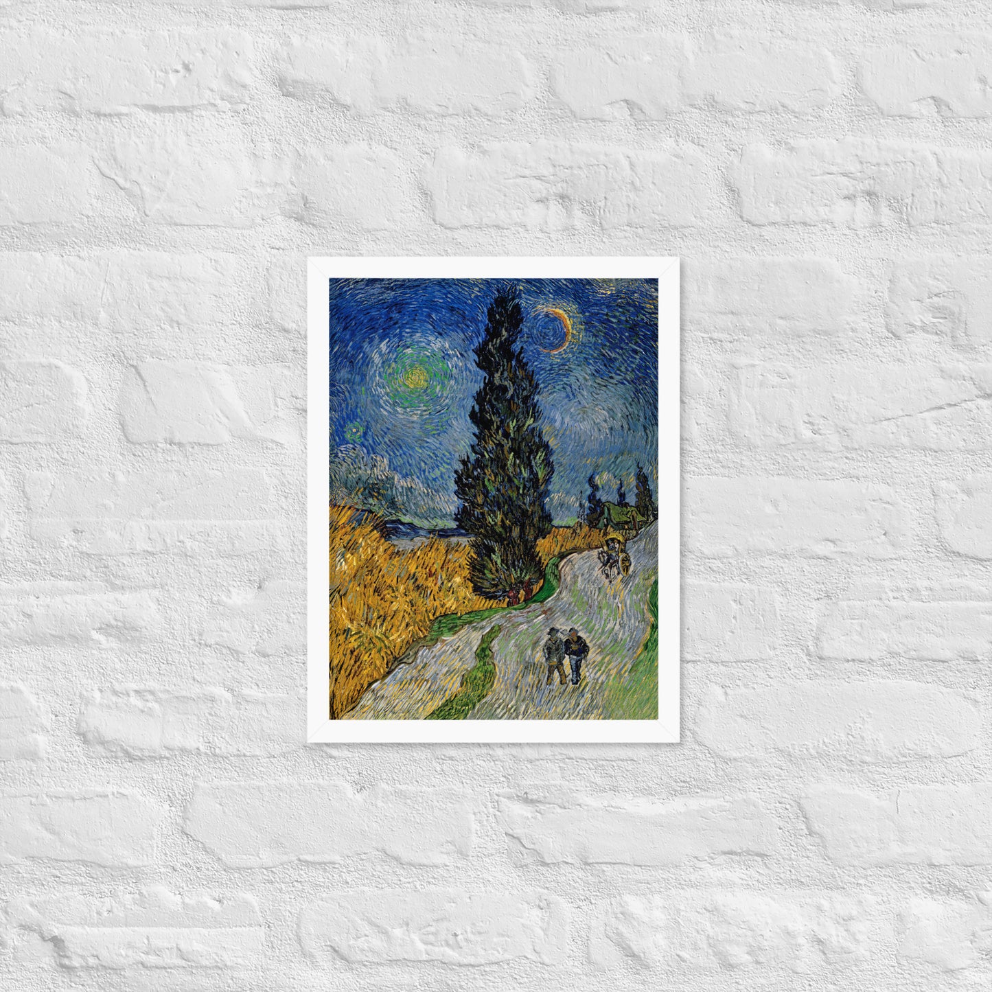 Van Gogh's 'Road with Cypress and Star' on a 12"x16" white framed poster print on a white brick wall.