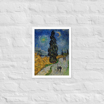Van Gogh's 'Road with Cypress and Star' on a 12"x16" white framed poster print on a white brick wall.