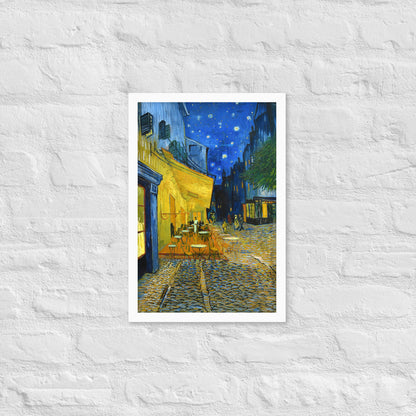 Van Gogh's 'Café Terrace at Night' on a 12"x18" white framed poster print on a white brick wall.