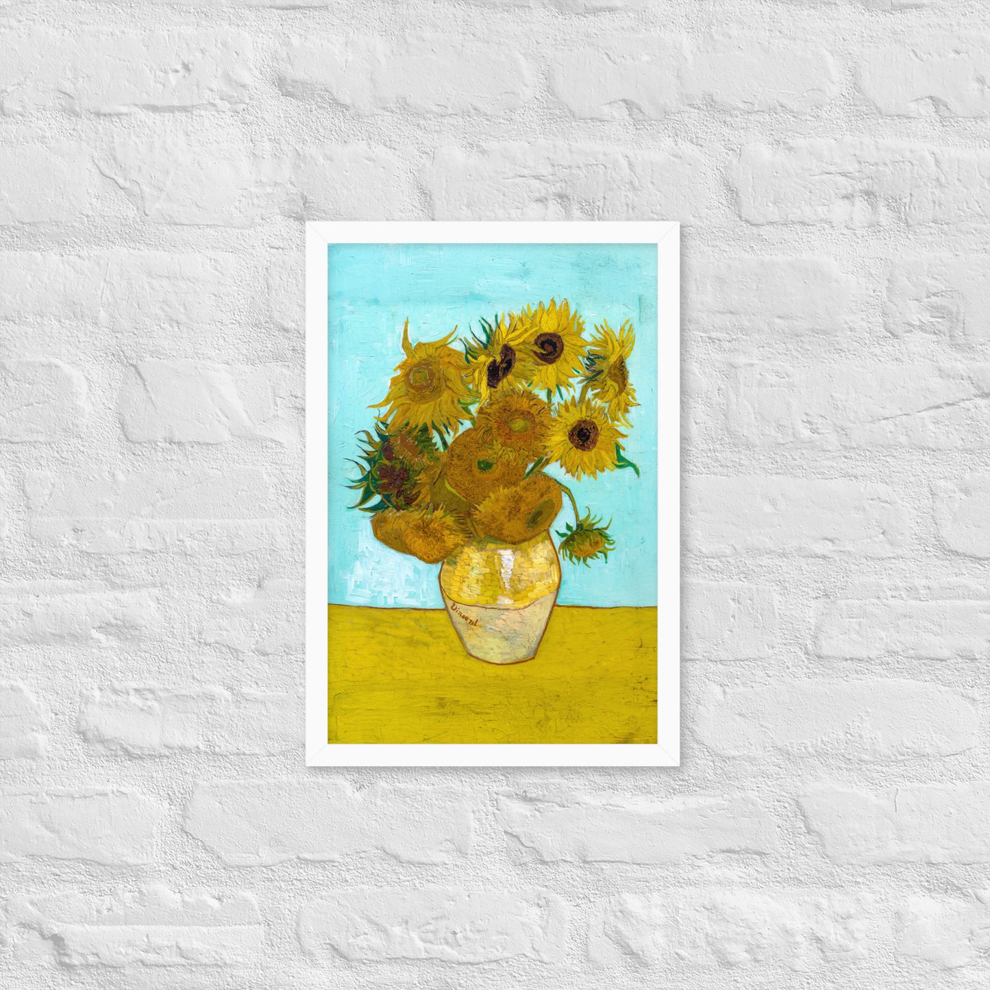 Van Gogh's 'Vase with Twelve Sunflowers' on a 12"x18" white framed poster print on a white brick wall.