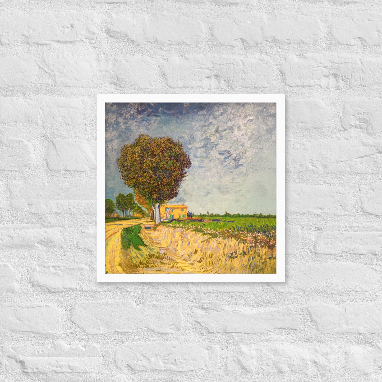 Van Gogh's 'A Lane near Arles' on a 16"x16" white framed poster print on a white brick wall.