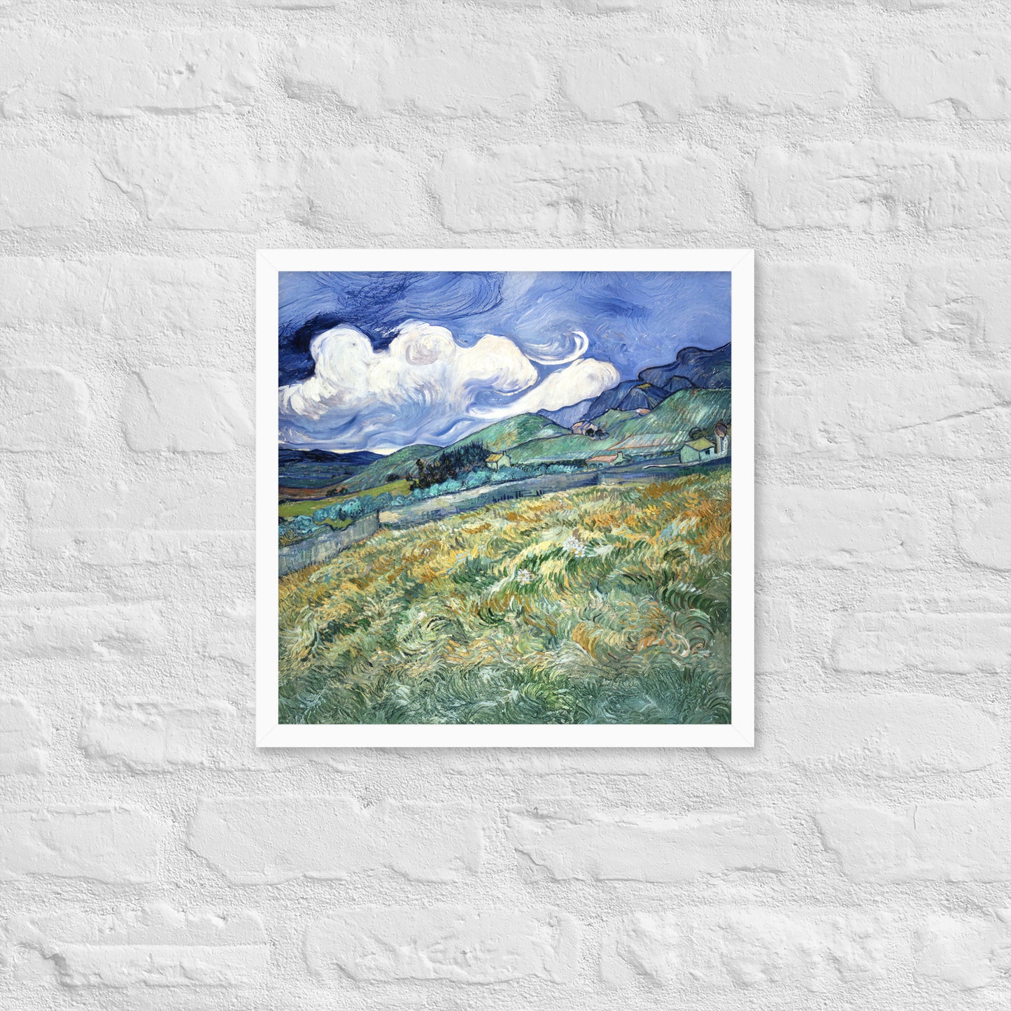 Van Gogh's 'Landscape from Saint-Rémy' on a 16"x16" white framed poster print on a white brick wall.