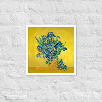 Van Gogh's 'Vase with Irises Against a Yellow Background' on a 16"x16" white framed poster print on a white brick wall.