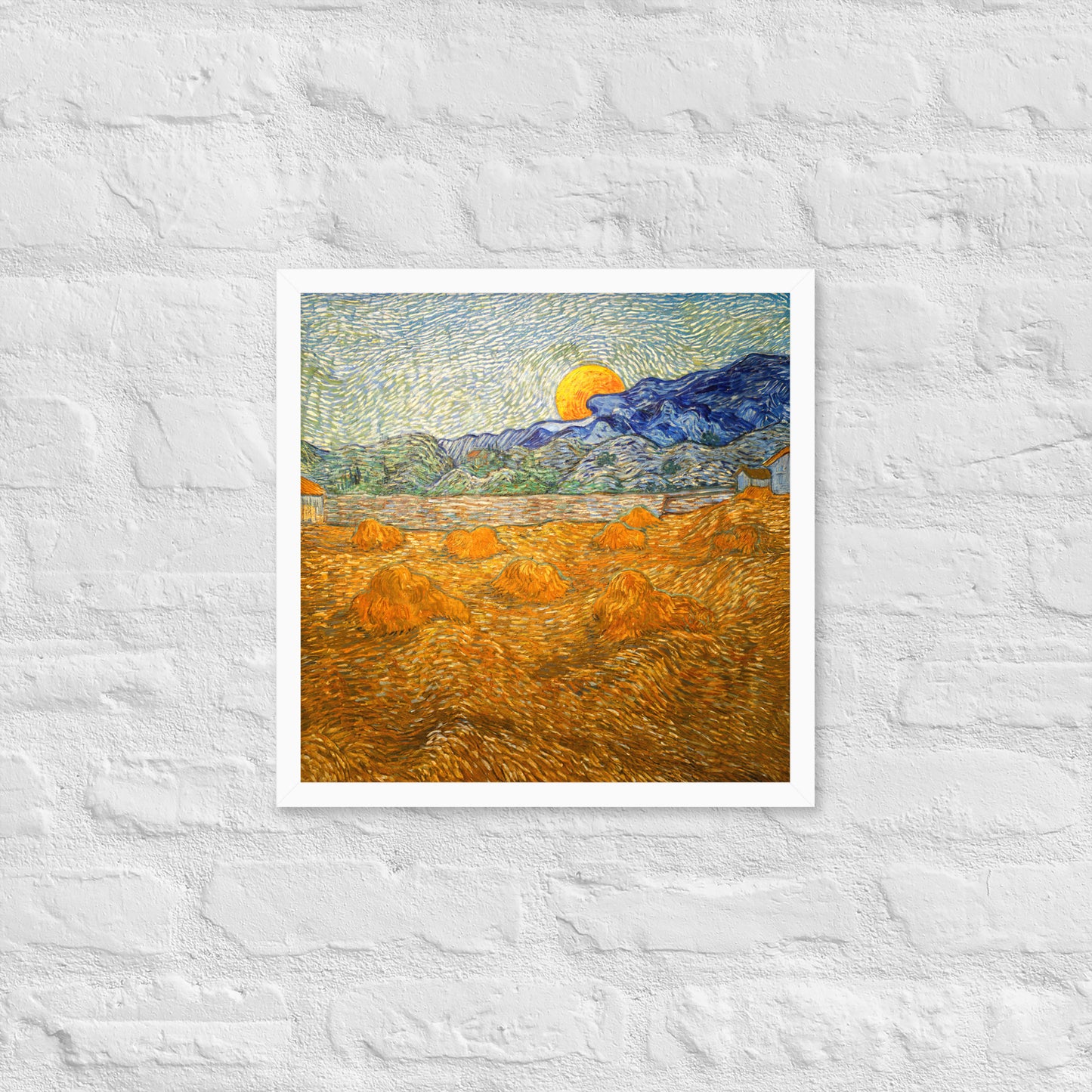 Van Gogh's 'Landscape with Wheat Sheaves and Rising Moon' on a 16"x16" white framed poster print on a white brick wall.