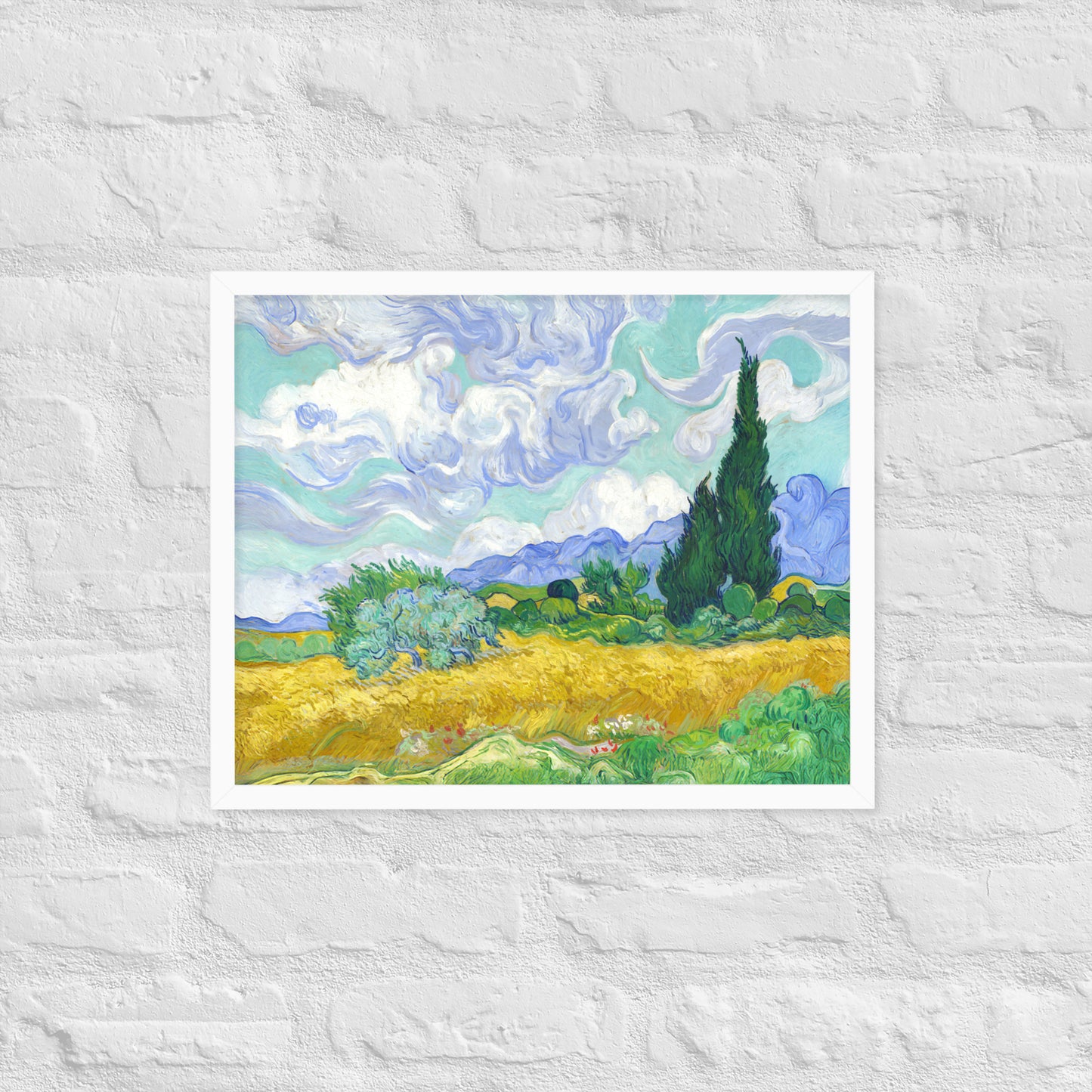 Van Gogh's 'Wheat Field with Cypresses' on a 16"x20" white framed poster print on a white brick wall.