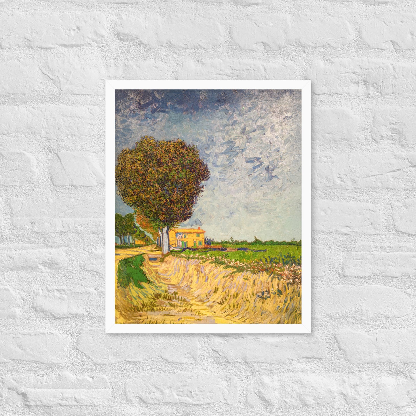 Van Gogh's 'A Lane near Arles' on a 16"x20" white framed poster print on a white brick wall.