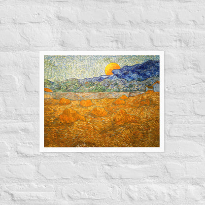 Van Gogh's 'Landscape with Wheat Sheaves and Rising Moon' on a 16"x20" white framed poster print on a white brick wall.