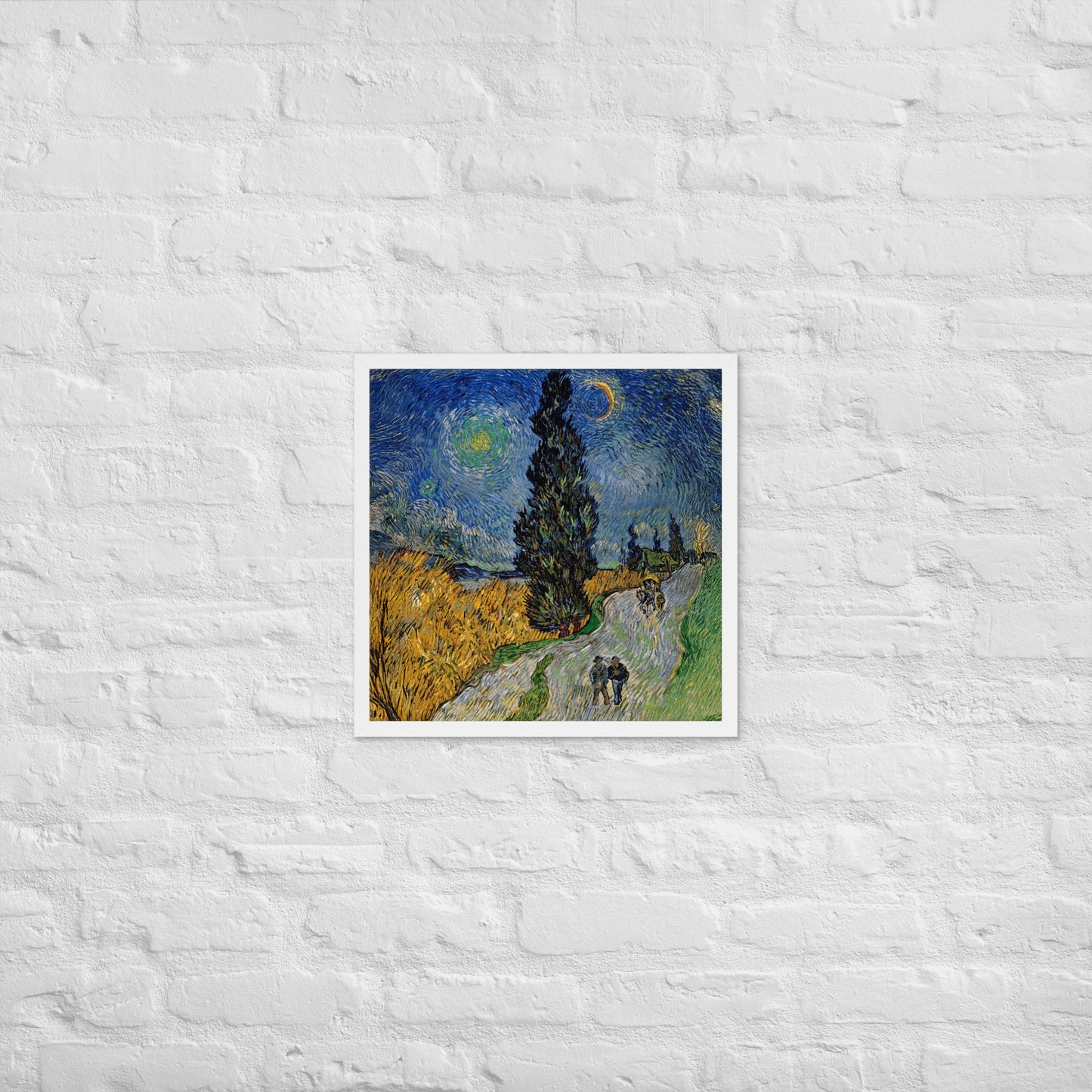 Van Gogh's 'Road with Cypress and Star' on a 18"x18" white framed poster print on a white brick wall.