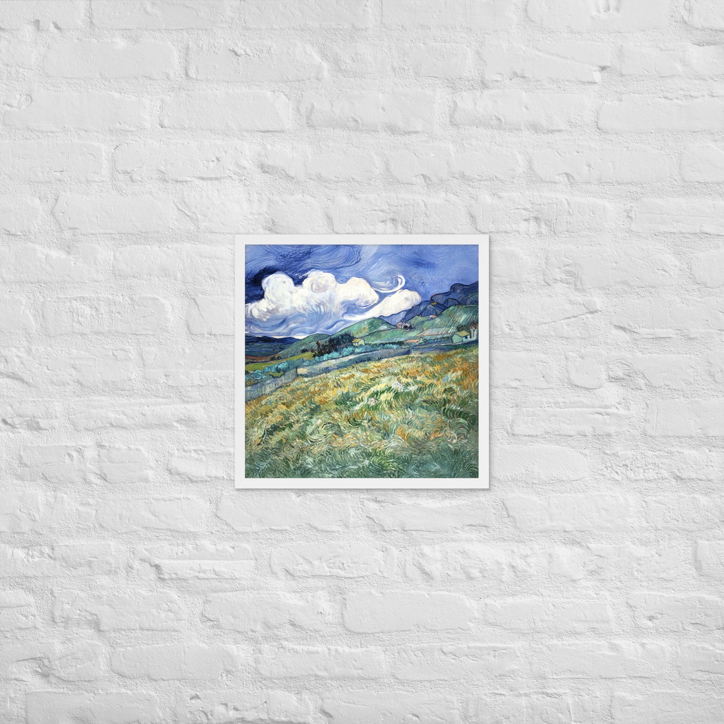 Van Gogh's 'Landscape from Saint-Rémy' on a 18"x18" white framed poster print on a white brick wall.