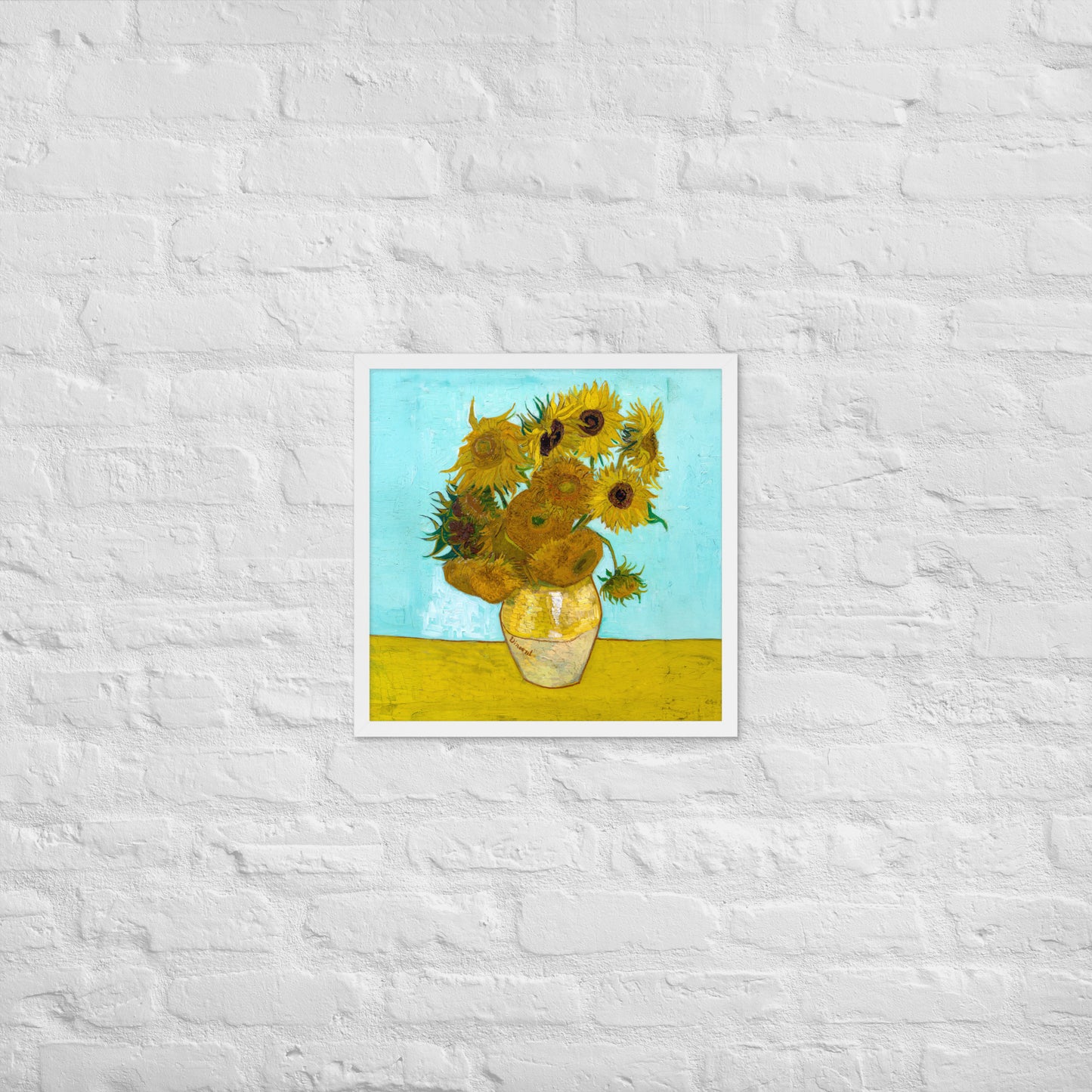 Van Gogh's 'Vase with Twelve Sunflowers' on a 18"x18" white framed poster print on a white brick wall.