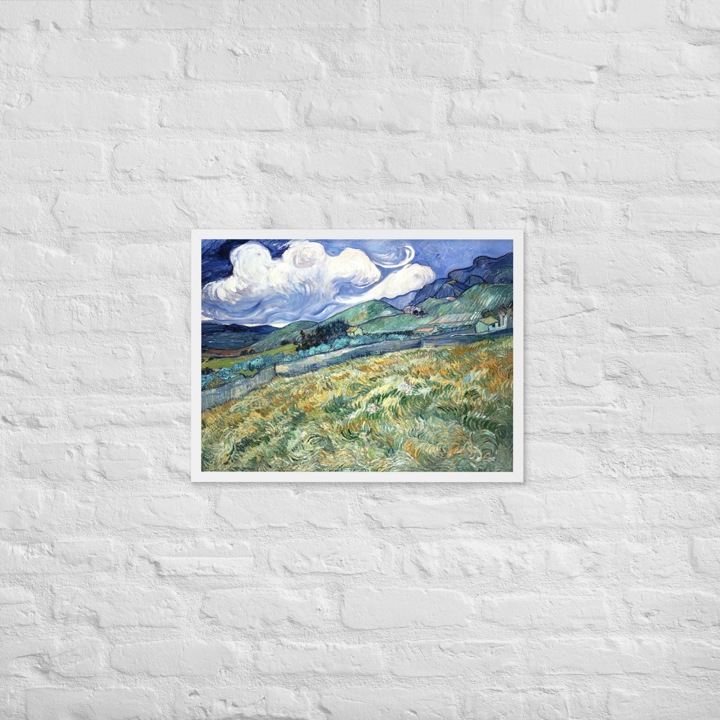 Van Gogh's 'Landscape from Saint-Rémy' on a 18"x24" white framed poster print on a white brick wall.