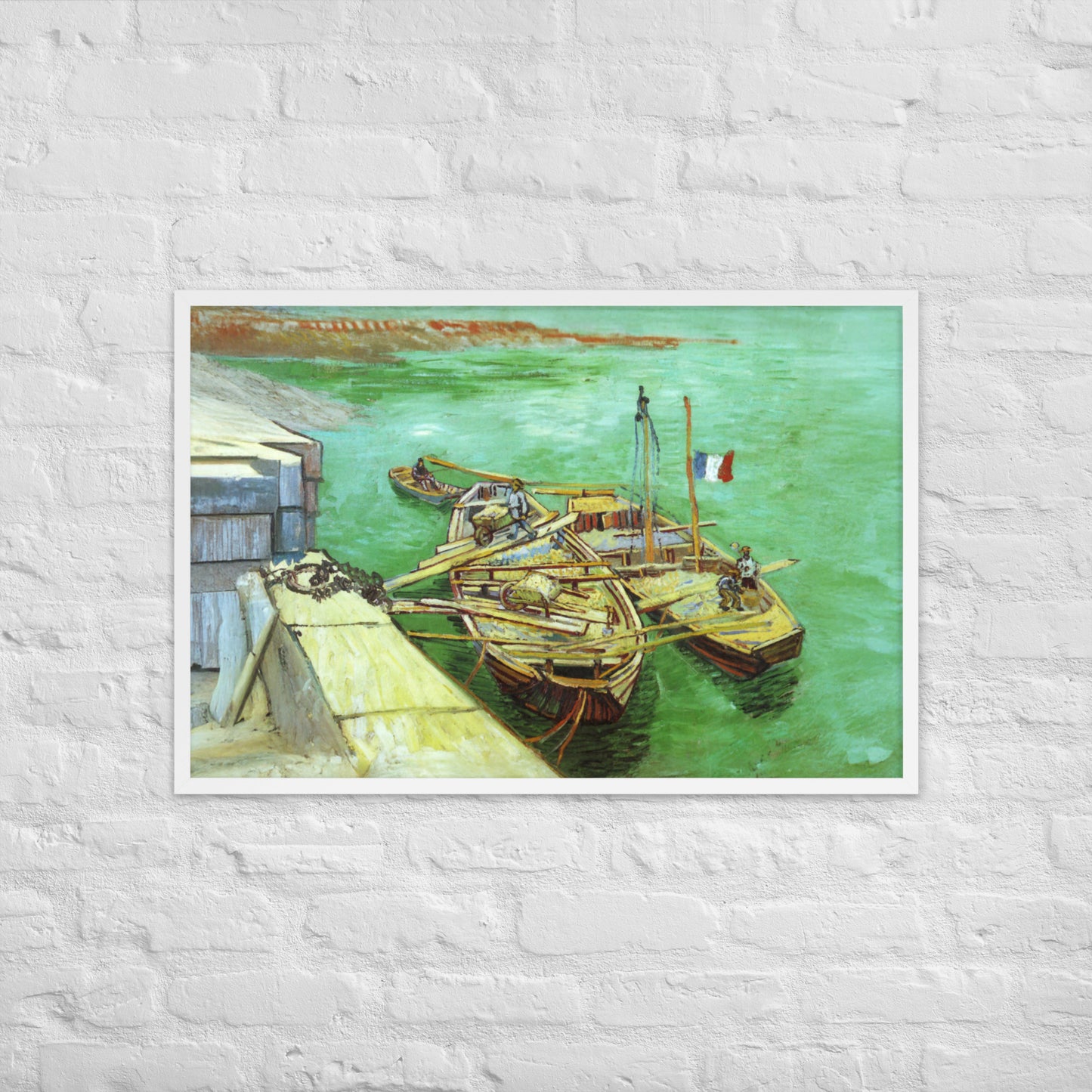 Van Gogh's 'Quay with Men Unloading Sand Barges' on a 24"x36" white framed poster print on a white brick wall.