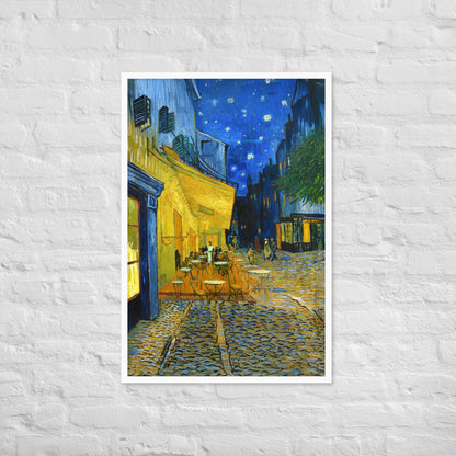 Van Gogh's 'Café Terrace at Night' on a 24"x36" white framed poster print on a white brick wall.