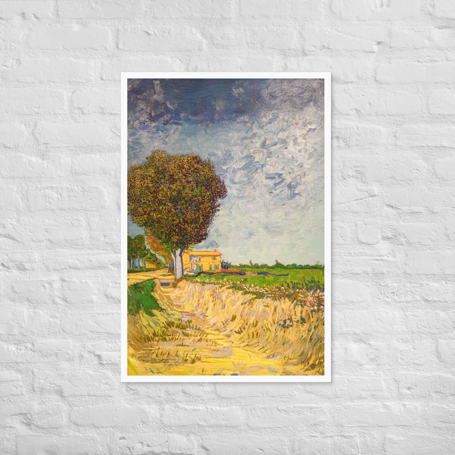 Van Gogh's 'A Lane near Arles' on a 24"x36" white framed poster print on a white brick wall.