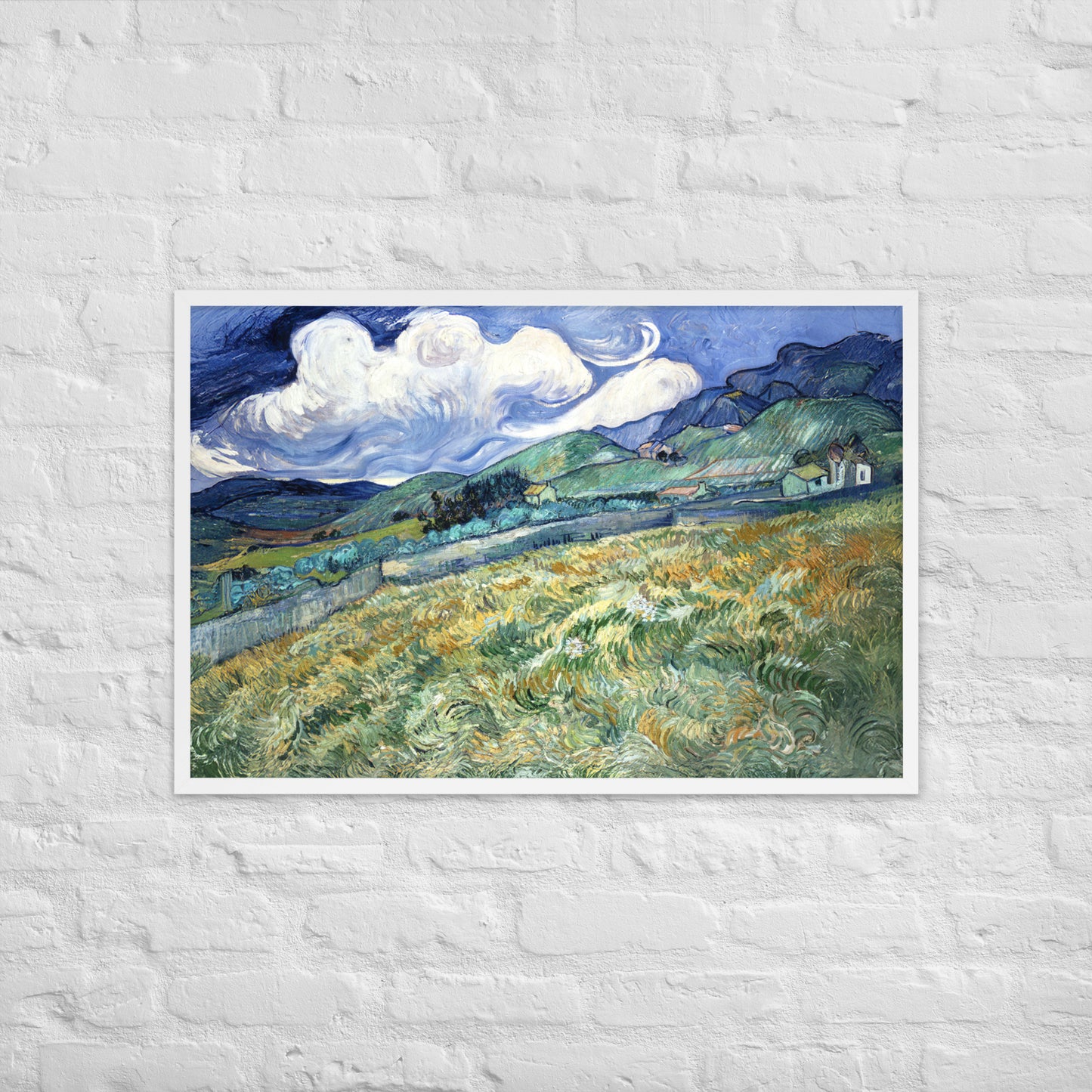 Van Gogh's 'Landscape from Saint-Rémy' on a 24"x36" white framed poster print on a white brick wall.