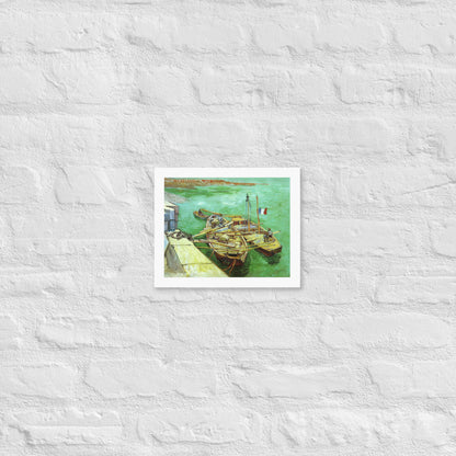 Van Gogh's 'Quay with Men Unloading Sand Barges' on a 8"x10" white framed poster print on a white brick wall.
