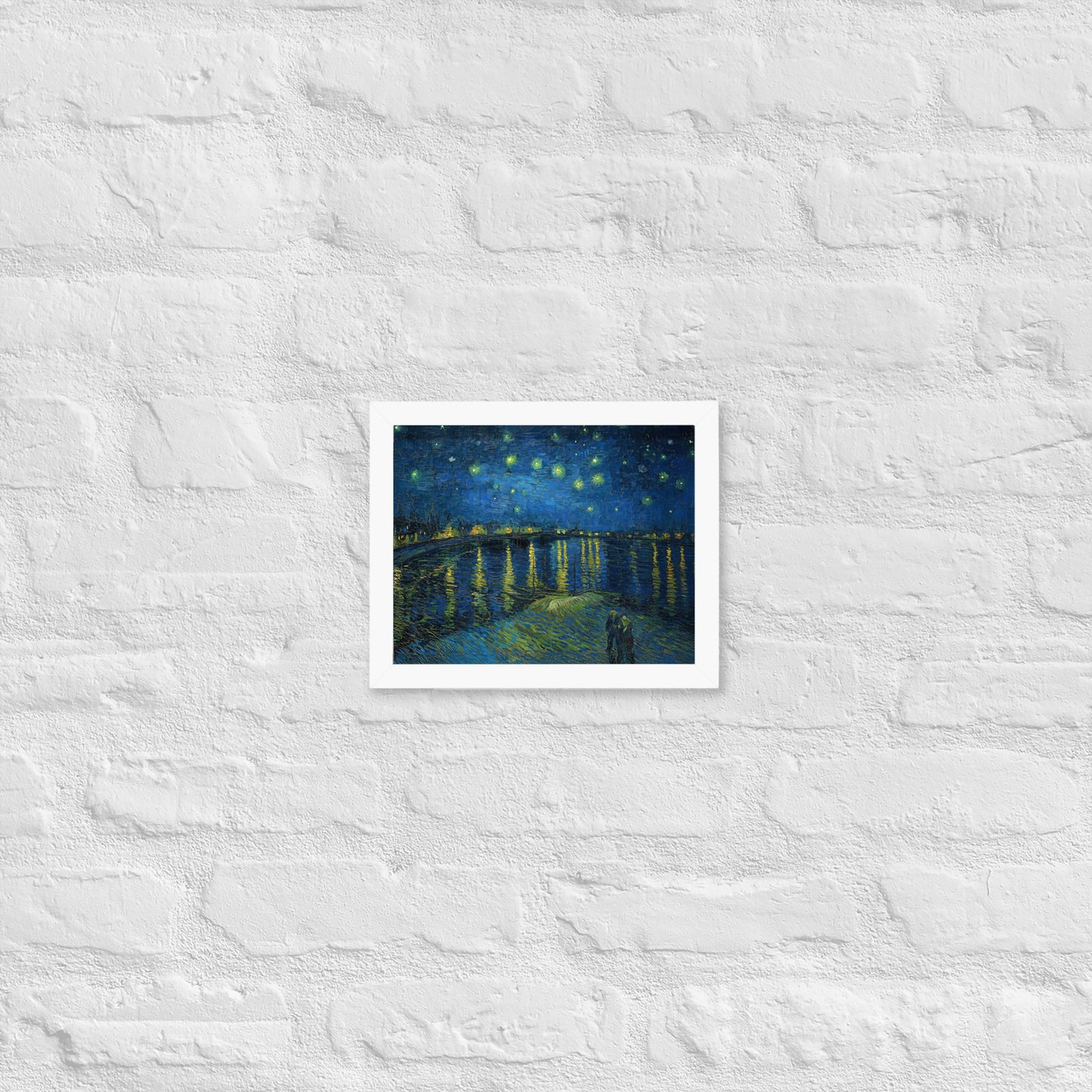Van Gogh's 'Starry Night Over the Rhone' on a 8"x10" white framed poster print on a white brick wall.