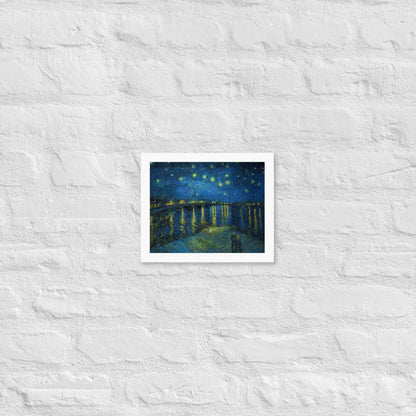 Van Gogh's 'Starry Night Over the Rhone' on a 8"x10" white framed poster print on a white brick wall.