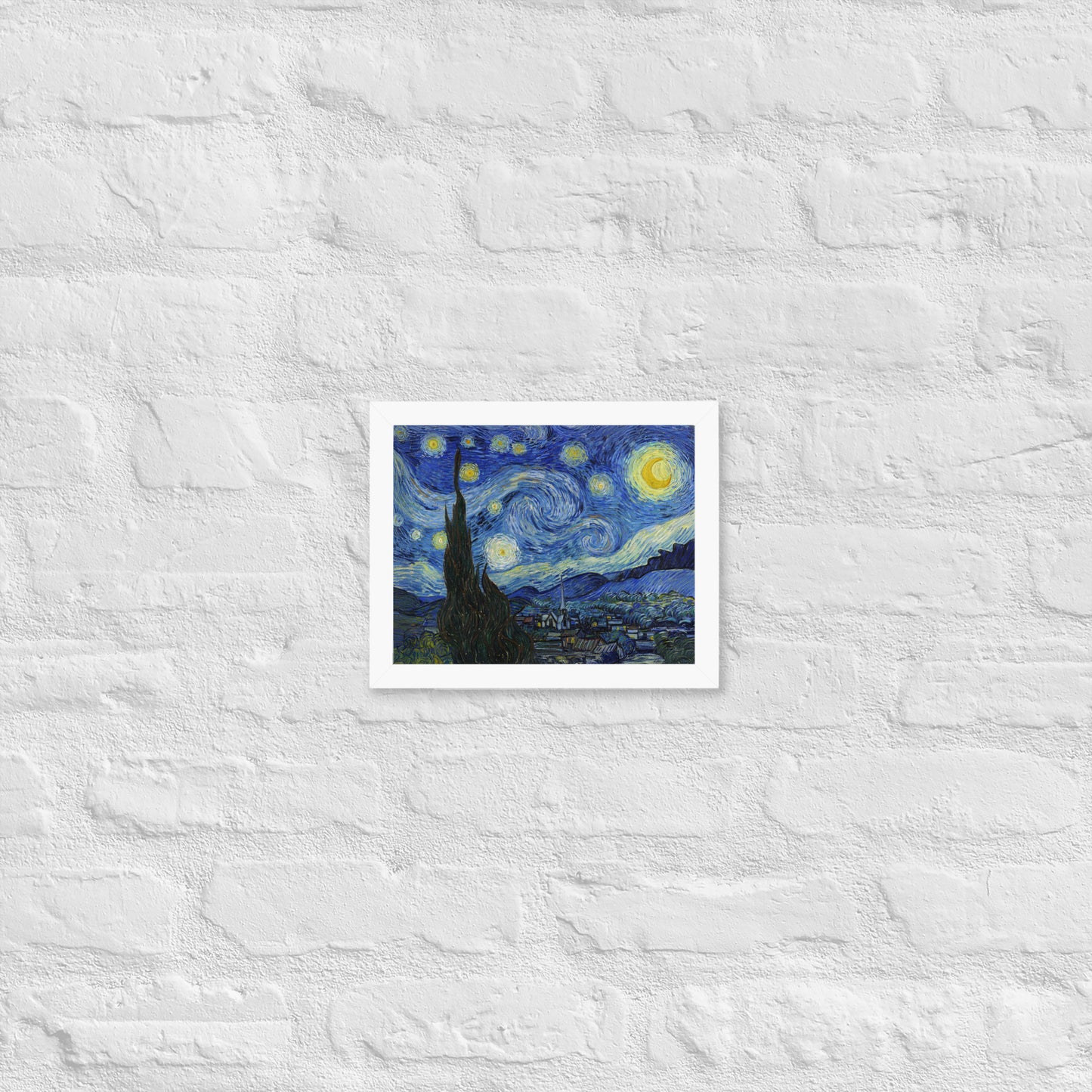 Van Gogh's 'Starry Night' on a 8"x10" white framed poster print on a white brick wall.