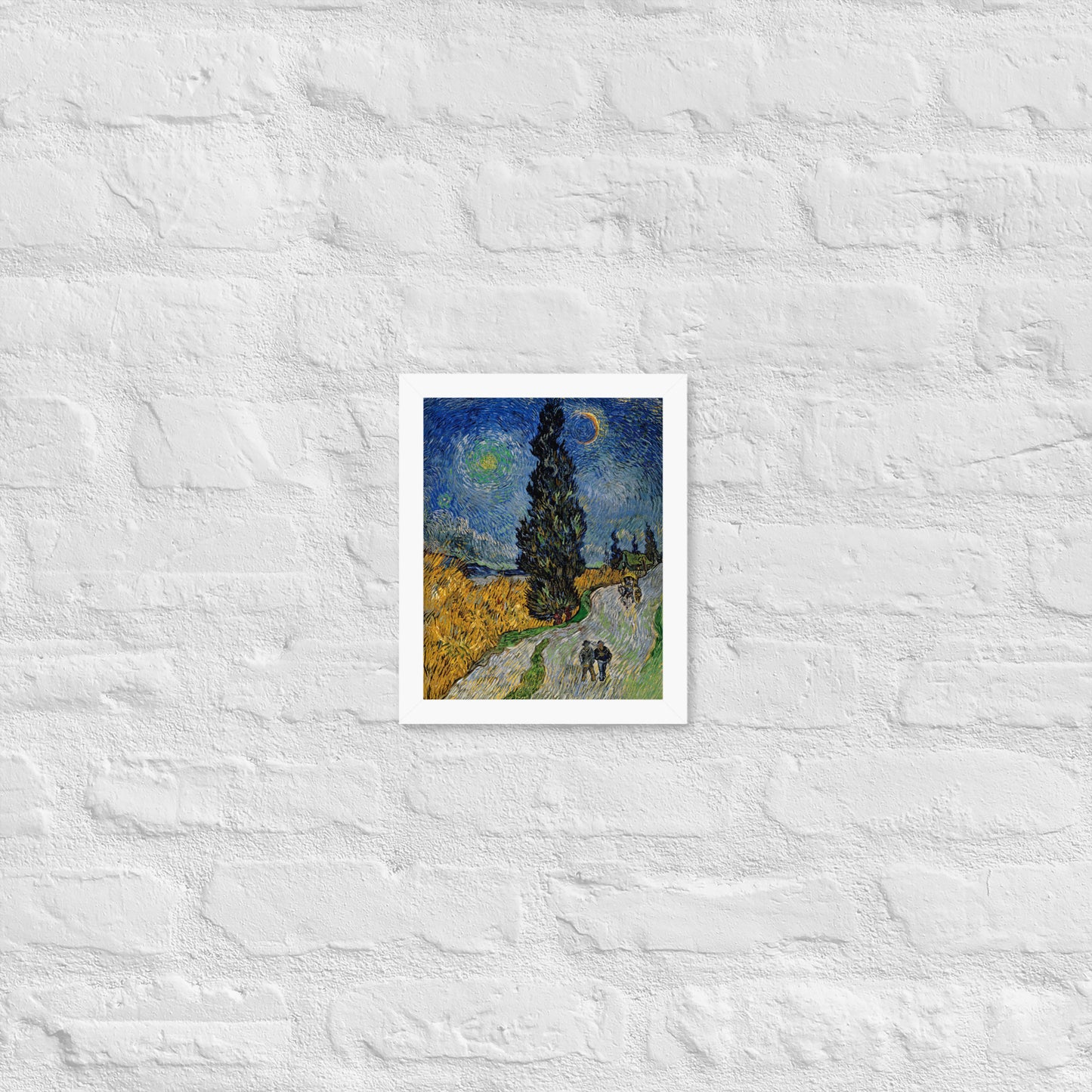 Van Gogh's 'Road with Cypress and Star' on a 8"x10" white framed poster print on a white brick wall.