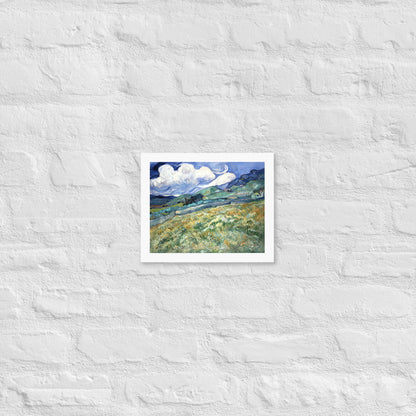 Van Gogh's 'Landscape from Saint-Rémy' on a 8"x10" white framed poster print on a white brick wall.