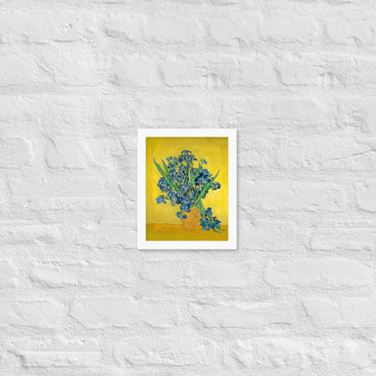 Van Gogh's 'Vase with Irises Against a Yellow Background' on a 8"x10" white framed poster print on a white brick wall.