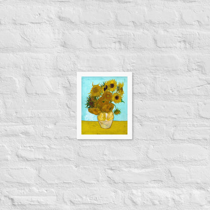 Van Gogh's 'Vase with Twelve Sunflowers' on a 8"x10" white framed poster print on a white brick wall.