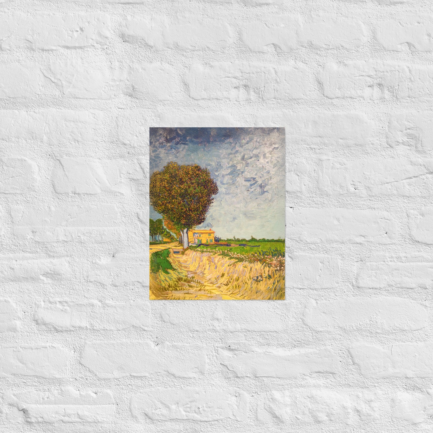 Van Gogh's 'A Lane near Arles' on a 11"x14" unframed poster print on a white brick wall.