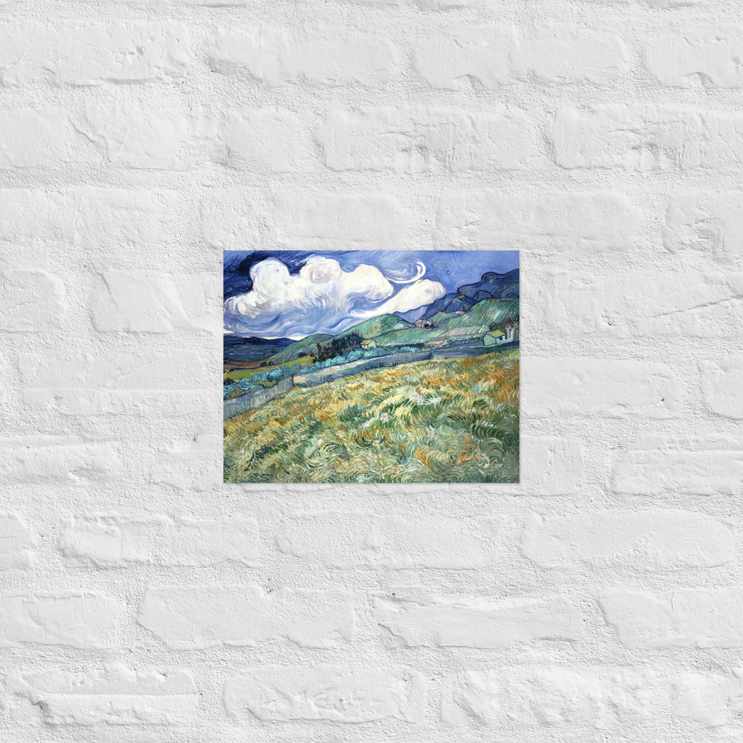 Van Gogh's 'Landscape from Saint-Rémy' on a 11"x14" unframed poster print on a white brick wall.
