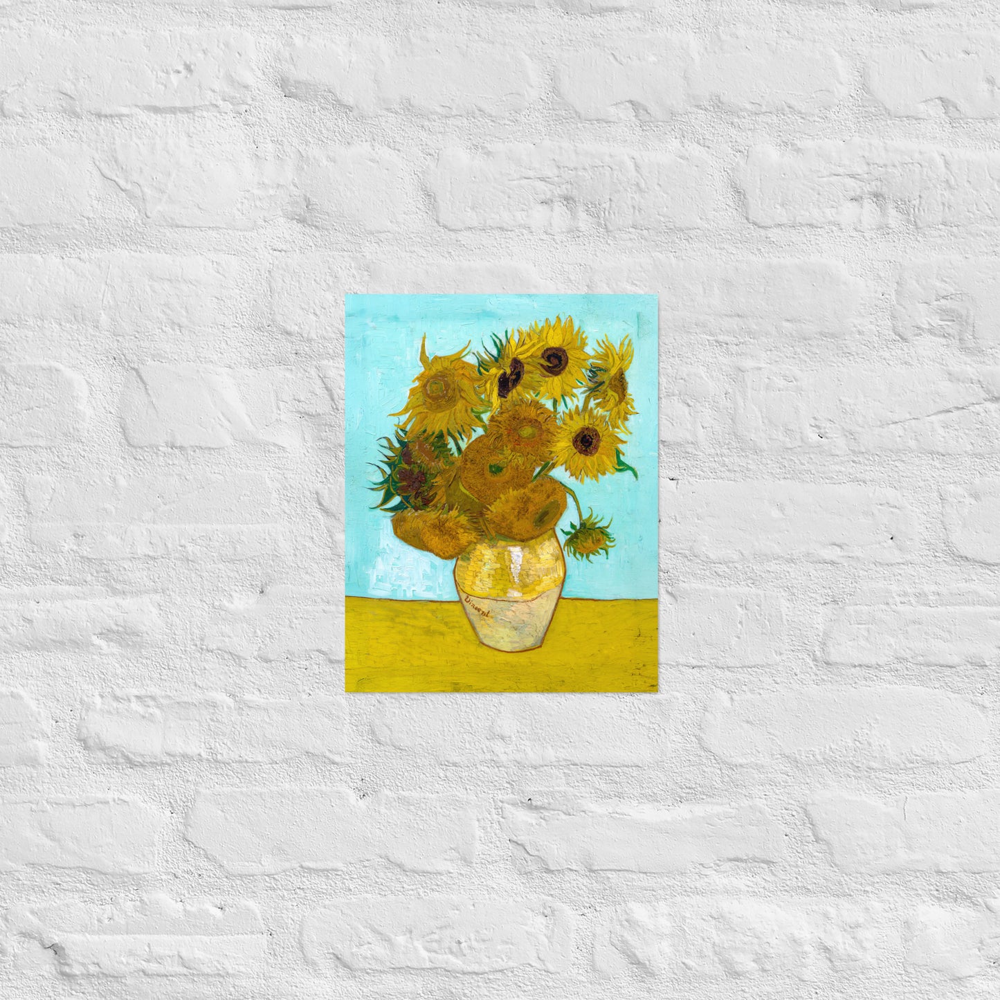 Van Gogh's 'Vase with Twelve Sunflowers' on a 11"x14" unframed poster print on a white brick wall.