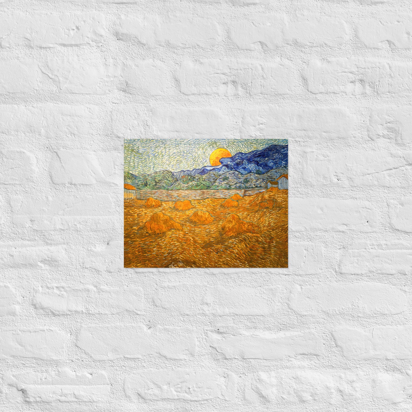 Van Gogh's 'Landscape with Wheat Sheaves and Rising Moon' on a 11"x14" unframed poster print on a white brick wall.