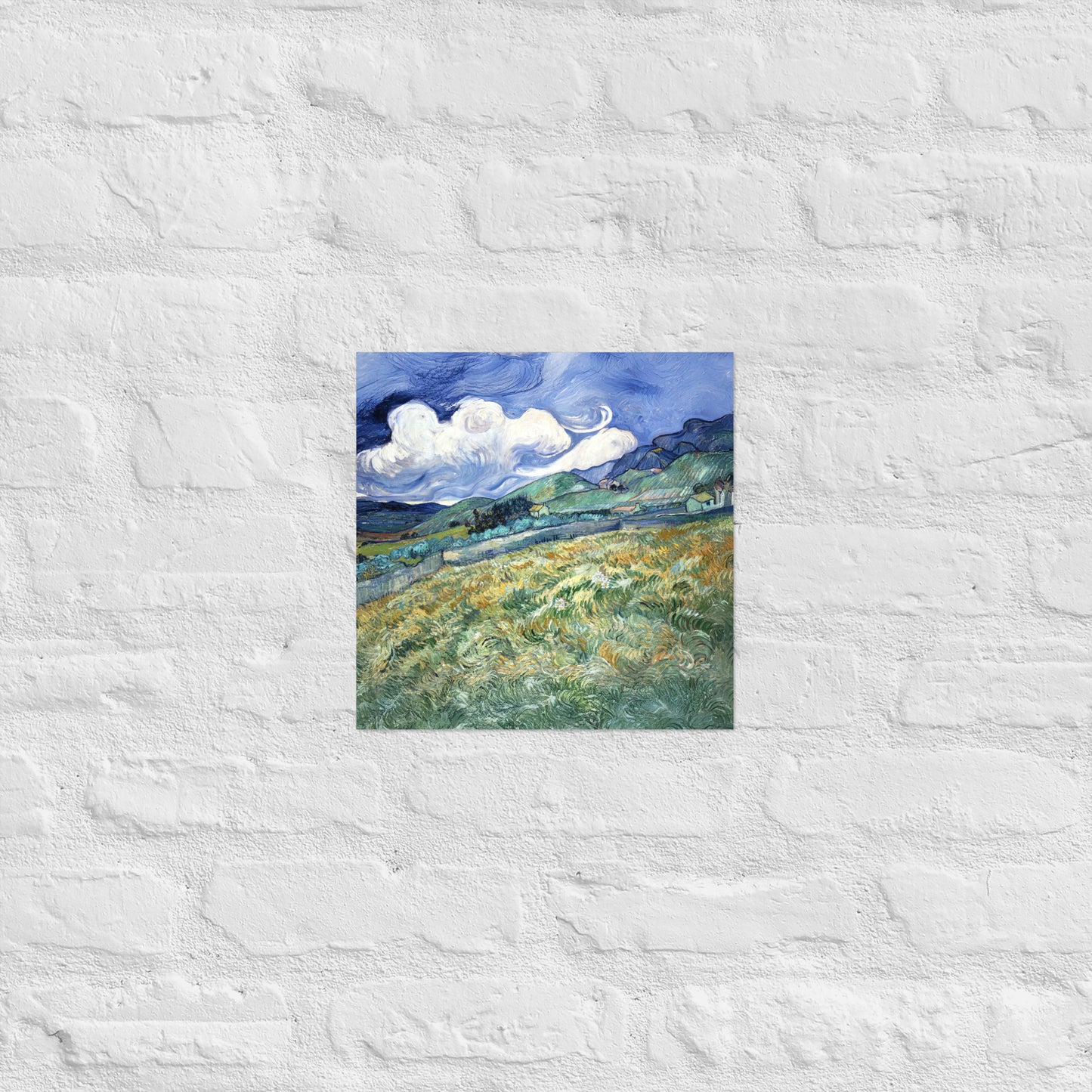Van Gogh's 'Landscape from Saint-Rémy' on a 12"x12" unframed poster print on a white brick wall.