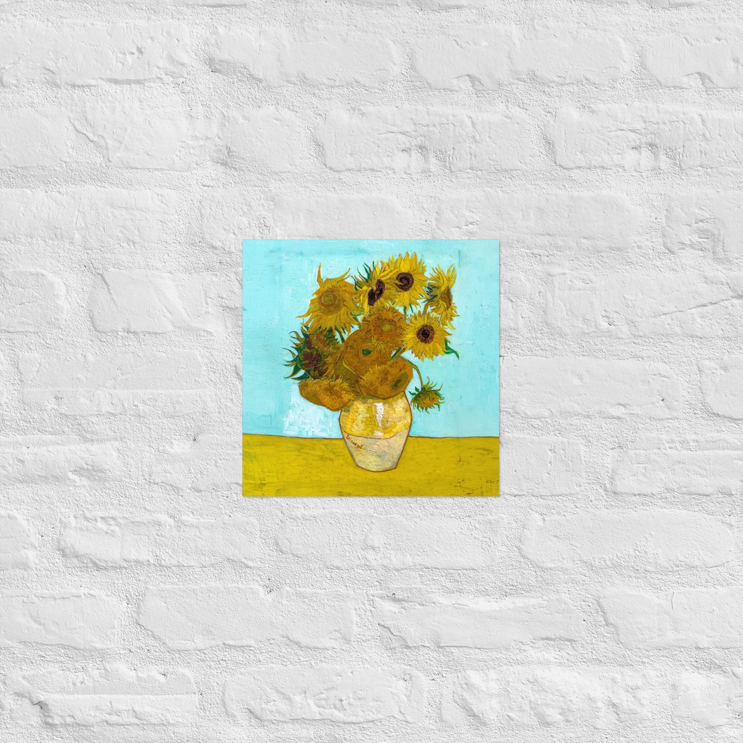 Van Gogh's 'Vase with Twelve Sunflowers' on a 12"x12" unframed poster print on a white brick wall.
