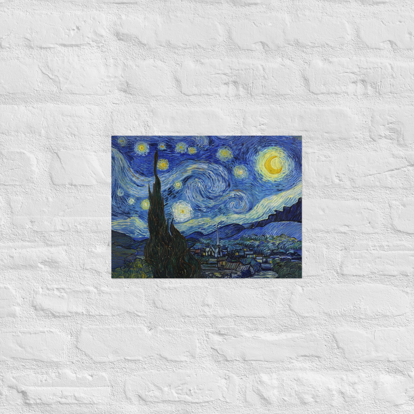 Van Gogh's 'Starry Night' on a 12"x16" unframed poster print on a white brick wall.