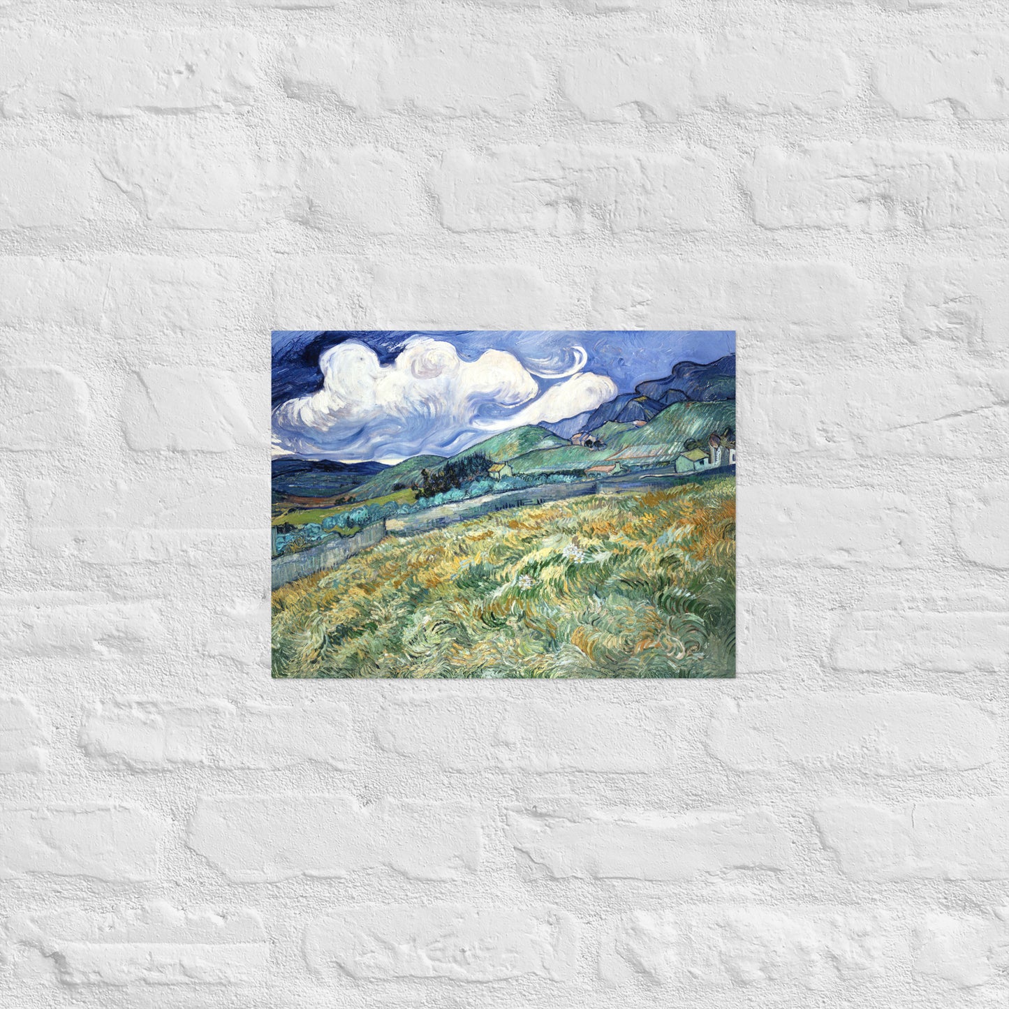 Van Gogh's 'Landscape from Saint-Rémy' on a 12"x16" unframed poster print on a white brick wall.