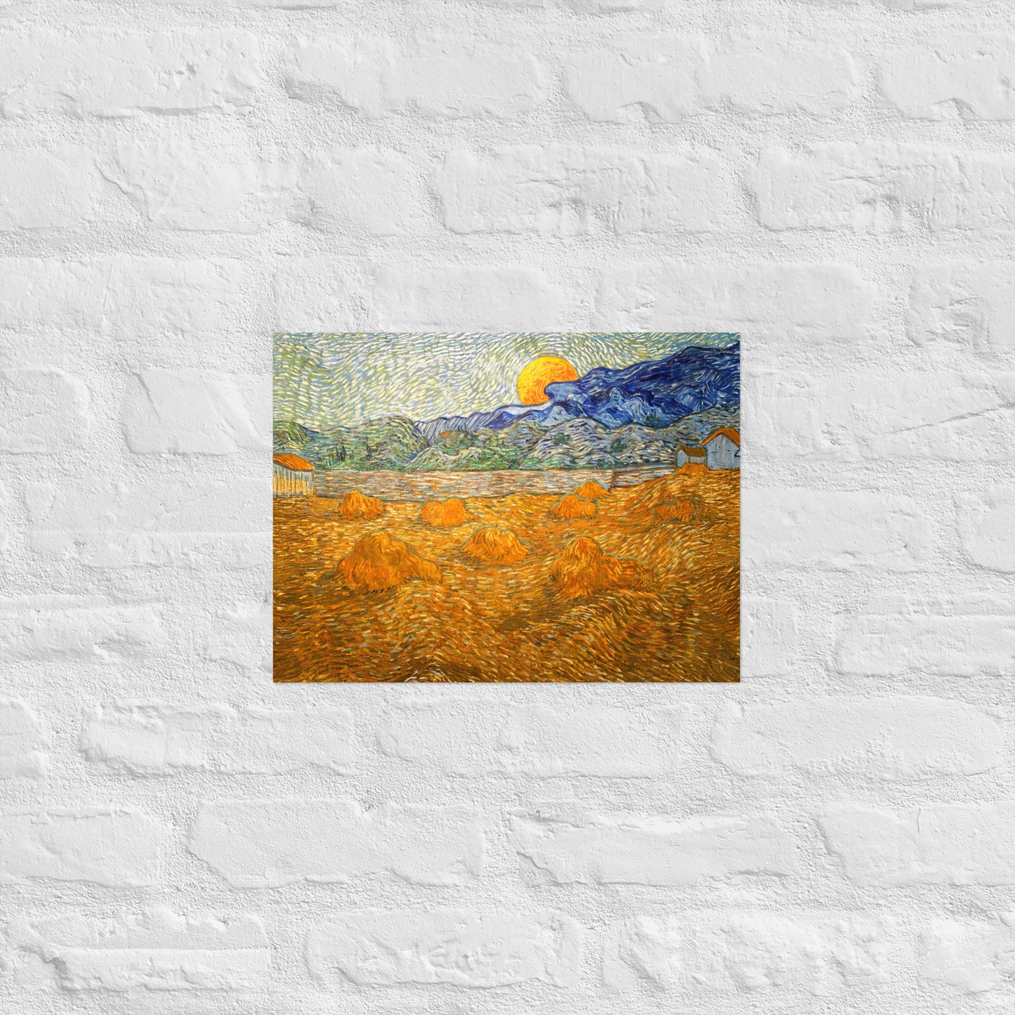 Van Gogh's 'Landscape with Wheat Sheaves and Rising Moon' on a 12"x16" unframed poster print on a white brick wall.