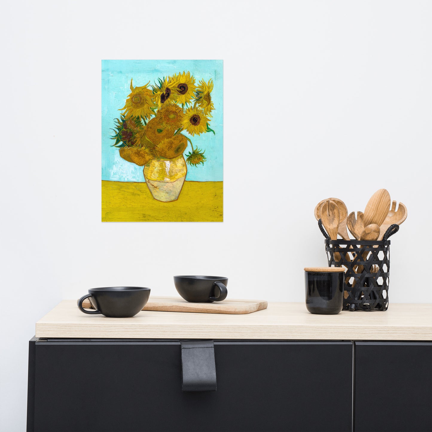 Van Gogh's 'Vase with Twelve Sunflowers' on a 12"x16" unframed poster print on a white wall above a kitchen counter with cooking supplies.