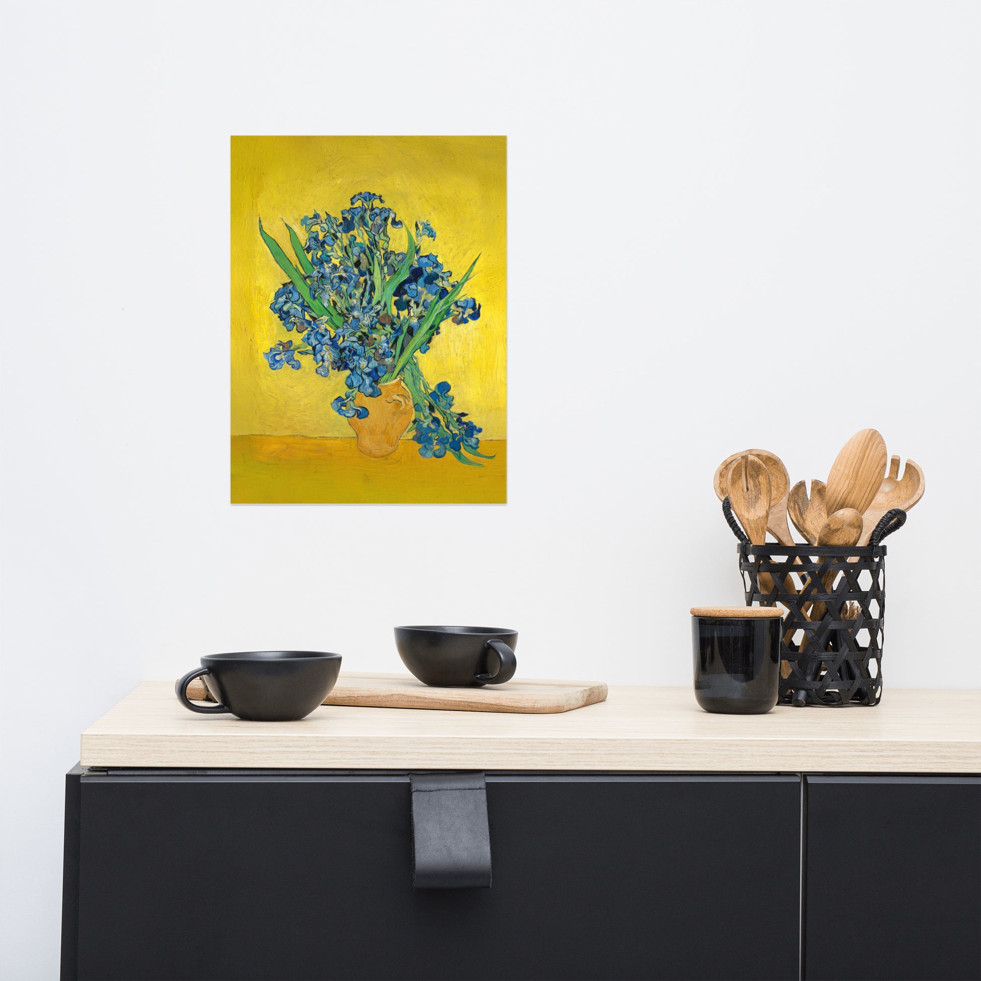 Van Gogh's 'Vase with Irises Against a Yellow Background' on a 12"x16" unframed poster print on a white wall above a kitchen counter with cooking supplies.