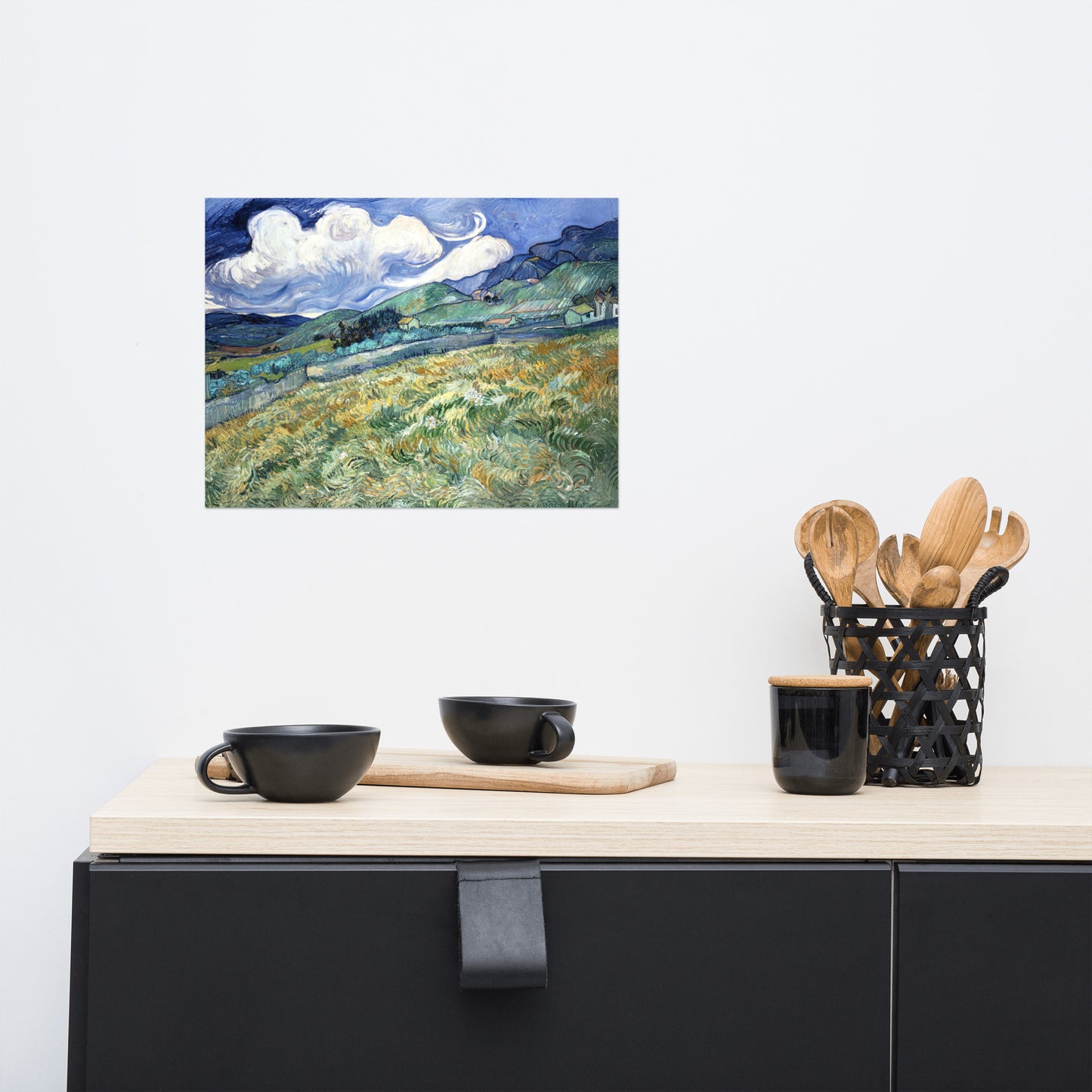 Van Gogh's 'Landscape from Saint-Rémy' on a 12"x16" unframed poster print on a white wall above a kitchen counter with cooking supplies.