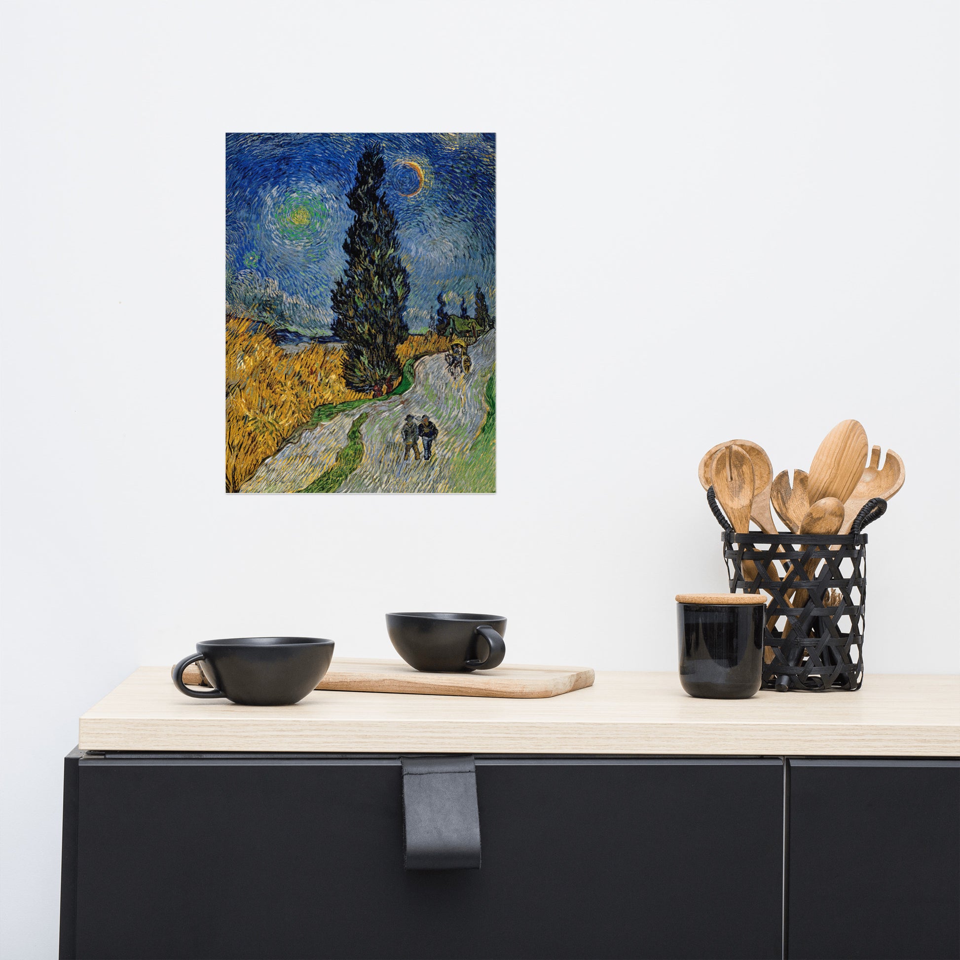 Van Gogh's 'Road with Cypress and Star' on a 12"x16" unframed poster print on a white wall above a kitchen counter with cooking supplies.