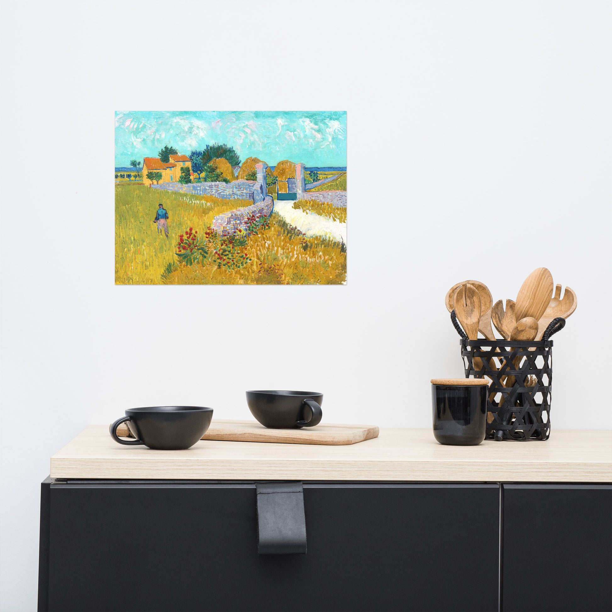 Van Gogh's 'Farmhouse in Provence' on a 12"x16" unframed poster print on a white wall above a kitchen counter with cooking supplies.