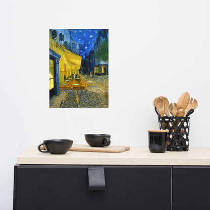 Van Gogh's 'Café Terrace at Night' on a 12"x16" unframed poster print on a white wall above a kitchen counter with cooking supplies.